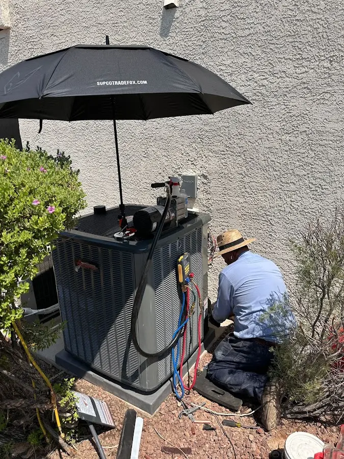 HVAC technician performing outdoor AC maintenance in Stoughton